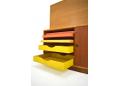 The base unit features sliding teak doors & coloured tray shelves.