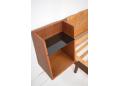 Teak bedside tables with black glass tops are side mounted to the frame and headboard.