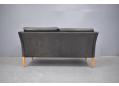 Low back 2 seat sofa made in Denmark with worn black leather upholstery.