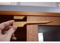 To move or remove the glass shelves, insert the wooden tools into the top of the sliding door.