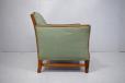 Brown leather armchair with high back and chrome legs and castors
