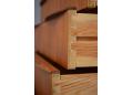 Wave shaped teak handles are fitted on the top of each drawer front.