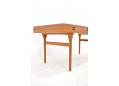 Iconic Danish desk in teak standing on rounded legs. Nanna Ditzel design.