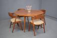Teak dining chairs with curved backs and cream upholstery produced by Korup Stolefabrik
