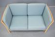 Compact 2 seater sofa with light blue fabric upholstery and beech showframe