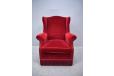Classic wingback armchair in red velour upholstery with reversable sprung cushion