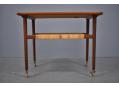 1953 design teak trolley with raised edges & woven cane shelf.