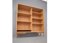 Oak bookcase standing on minimalist legs in solid oak.