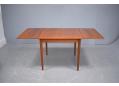 Extendable square dining table with teak top and tapering legs.