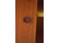 Each of the teak sliding doors have a pair of circular finger grips.