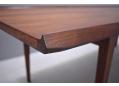 Lipped edge lounge table in rosewood with tapering legs.