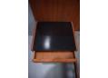 Teak bedside tables with dark purple glass tops are side mounted to the frame and headboard.