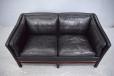Black colour leather upholstered 2 seat sofa with supportive seating.
