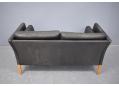 Beech wood legs on Danish box frame sofa in black leather.