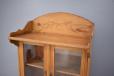 Decoratively carved frieze top on 1860s pine kitchen cabinet.
