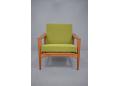 Model LARS armchair with green boucle fabric upholstered cushions.