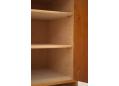 Shelves supported by movable brass pegs. SHelves are solid block wood construction