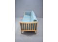 Light blue fabric upholstered 3 seat sofa with beech frame ends.