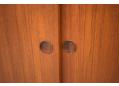 Each of the teak sliding doors have a pair of circular finger grips.