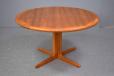 Round dining table extending to seat up to 10 people in vintage teak