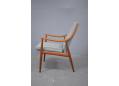 Comfortable and spacious armchair with curved frame in teak.